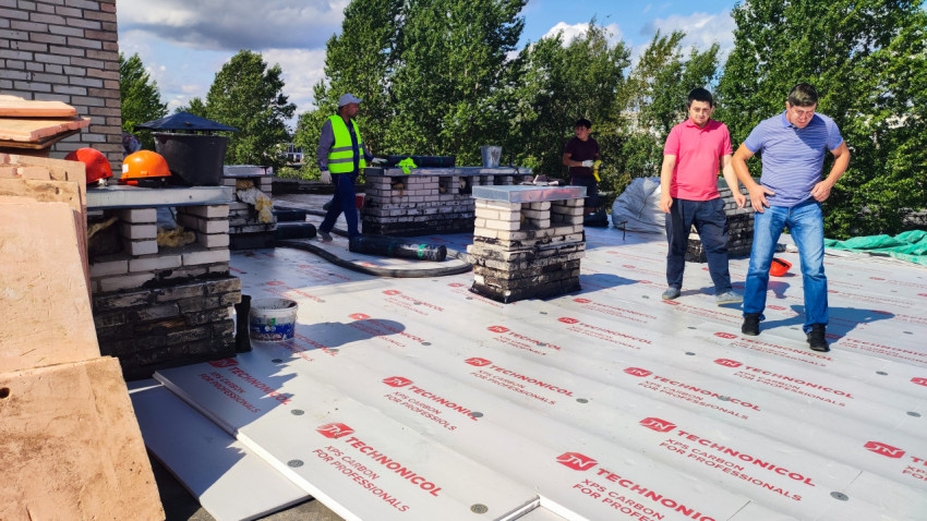 Рабочие на крыше здания во время ремонта