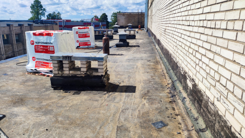 Крыша здания с материалами для ремонта и вентшахтами