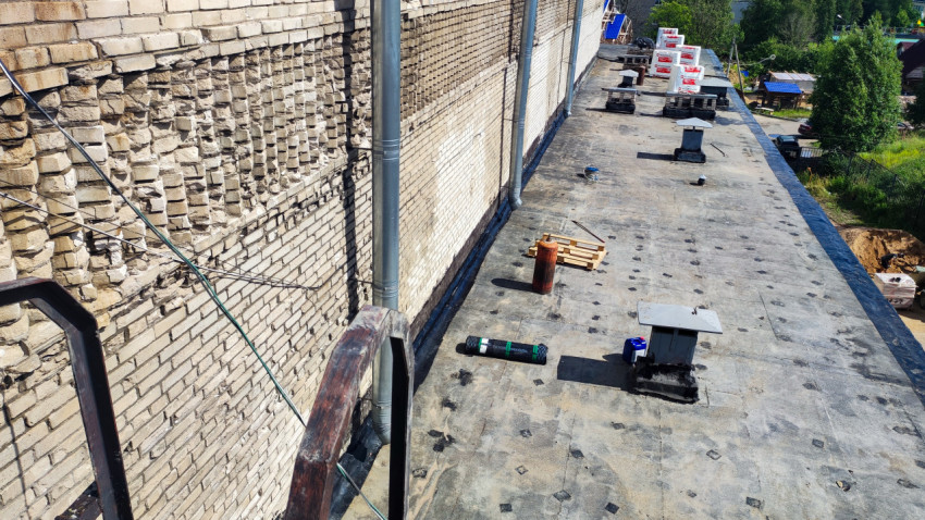 Плоская крыша здания с материалами для ремонта