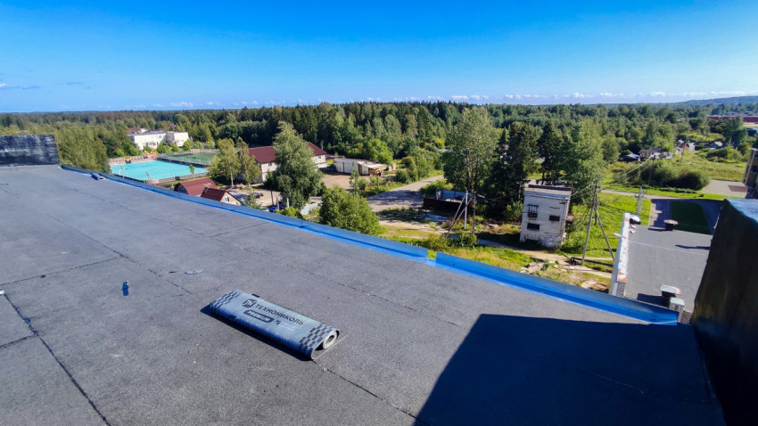 Плоская крыша с рулонной кровлей и видом на жилую застройку