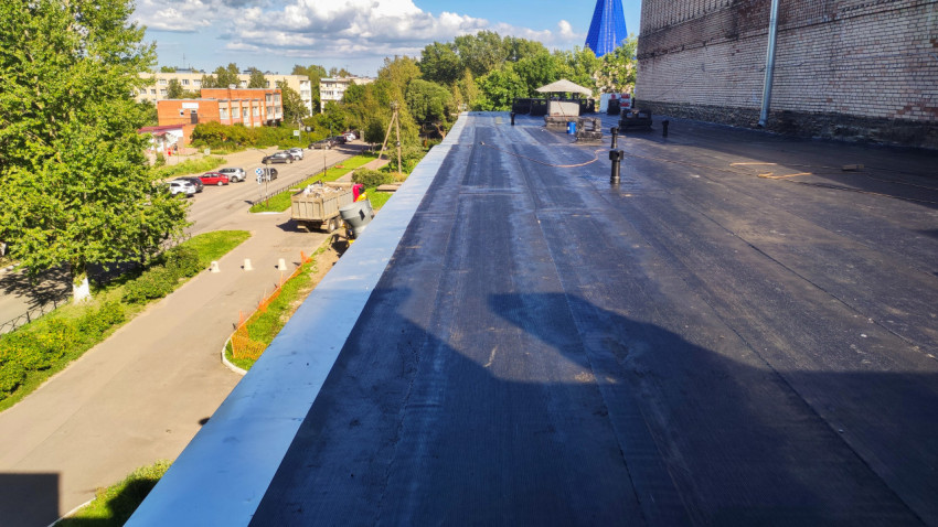Плоская крыша здания после ремонта рулонной кровлей