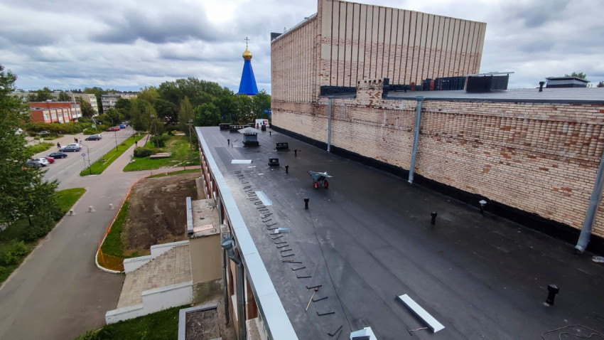 Плоская кровля здания и кирпичный фасад с ремонтом