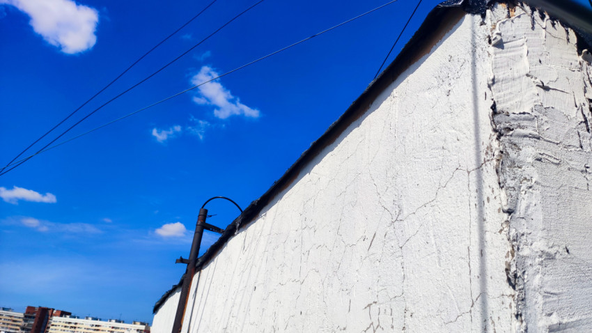 Верхняя часть стены с трещинами и проводами