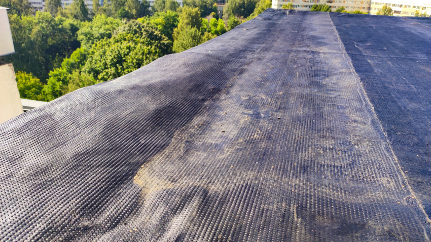 Участок крыши с рулонным покрытием и следами ремонта