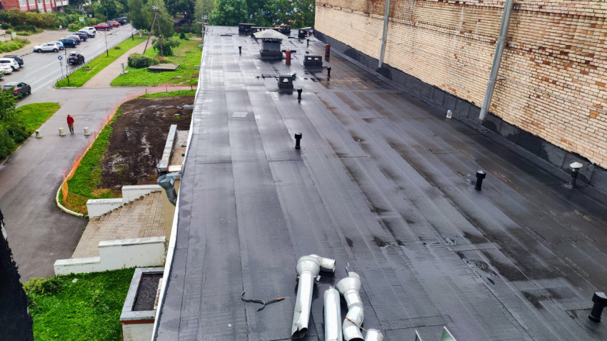 Вид на кровлю здания после ремонта рулонным материалом