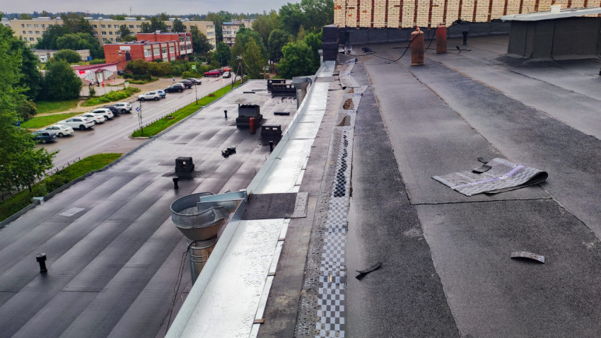 Плоская крыша здания с ремонтными материалами и городским видом