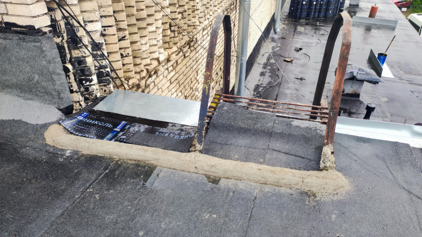 Участок крыши с металлической лестницей и примыканием к стене