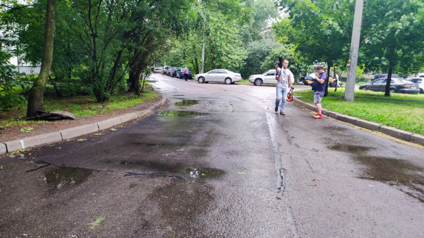 Асфальтированная дорога во дворе с людьми после дождя