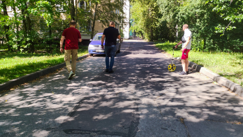 Инженеры проводят замеры на дворовой дороге