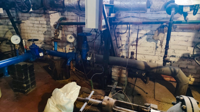 Трубопроводы и измерительные приборы в инженерном помещении теплового узла