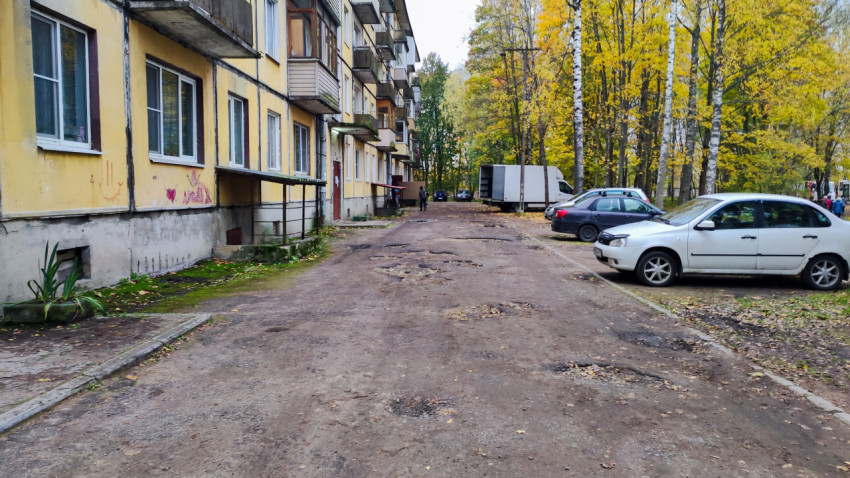 Подъезд жилого дома и двор с припаркованными машинами