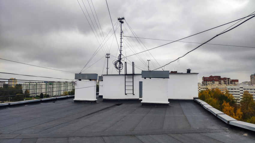 Плоская кровля с антенной стойкой и инженерными надстройками