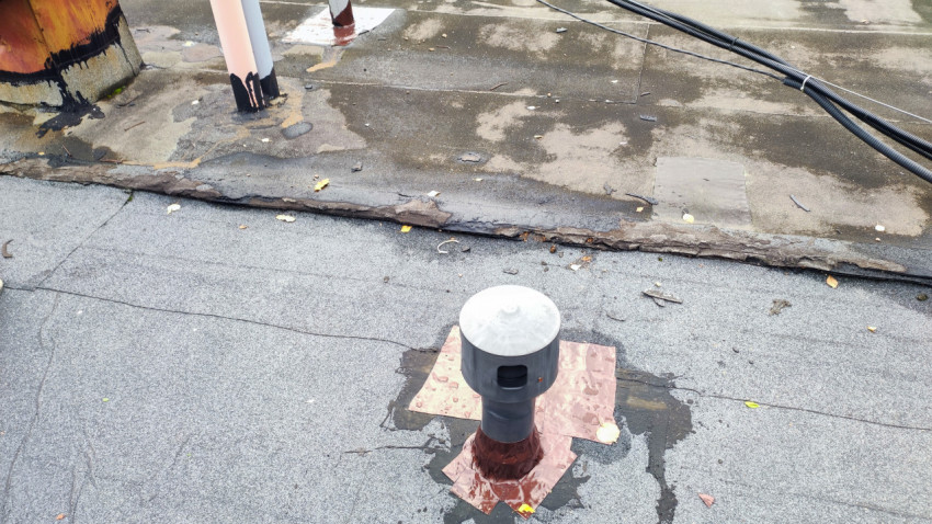 Вентиляционный выход и фрагмент рулонной кровли после частичного ремонта