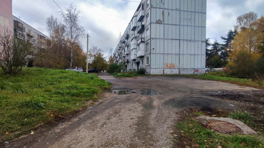 Панельный дом с дорогой и зелёной зоной в жилом районе