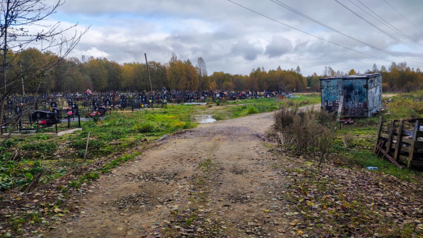 Сельское кладбище с надгробиями и металлическим контейнером