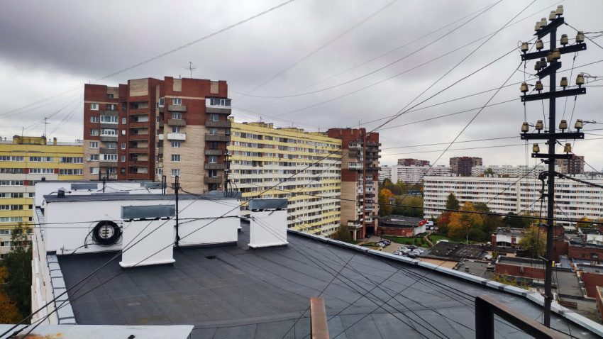 Вид на плоскую кровлю и панельные жилые дома позднесоветского периода