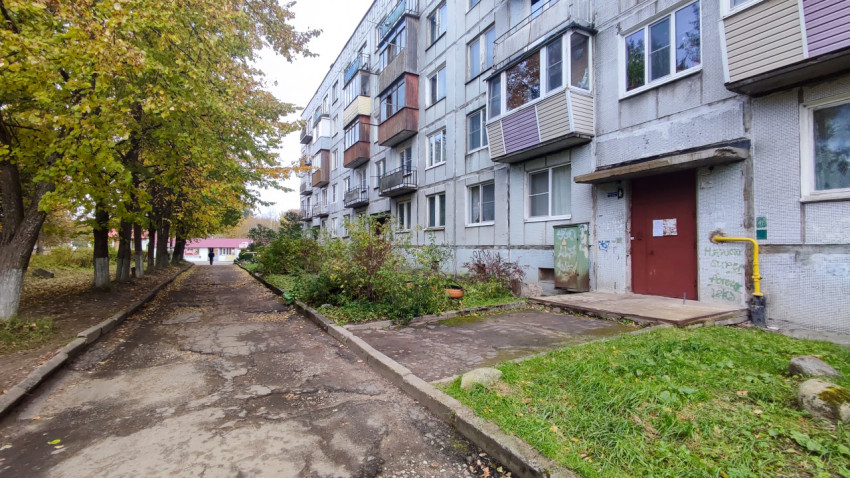 Панельный жилой дом с подъездами вдоль аллеи деревьев