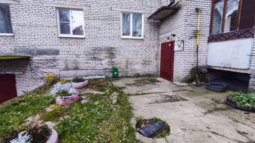 Подъезд жилого дома с клумбами из покрашенных шин