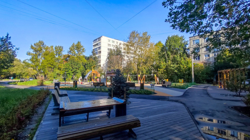 Вид на благоустроенный двор с детской площадкой и зонами отдыха