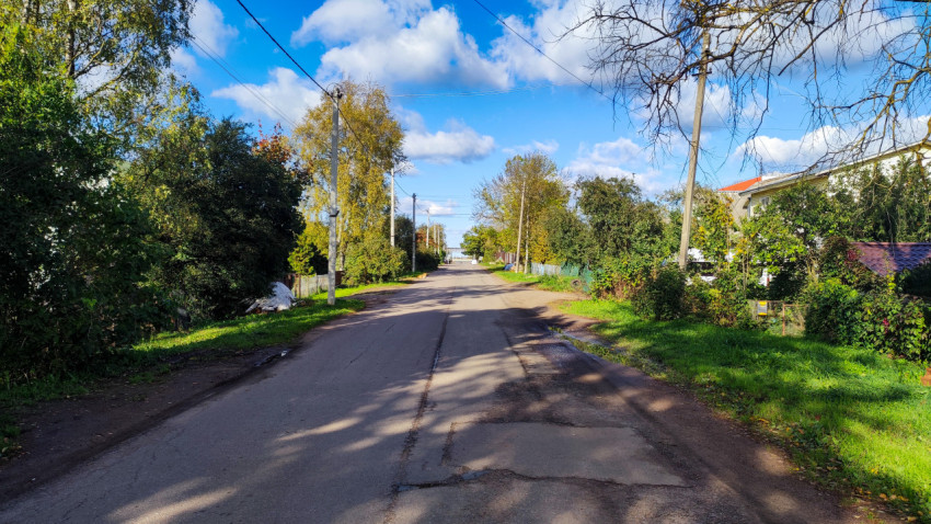 Улица с асфальтовым покрытием и тенями от деревьев