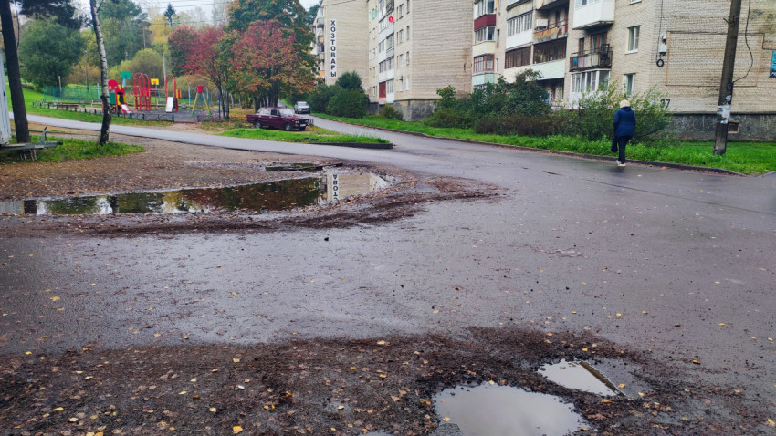 Дворовая территория с лужами и жилыми домами после дождя