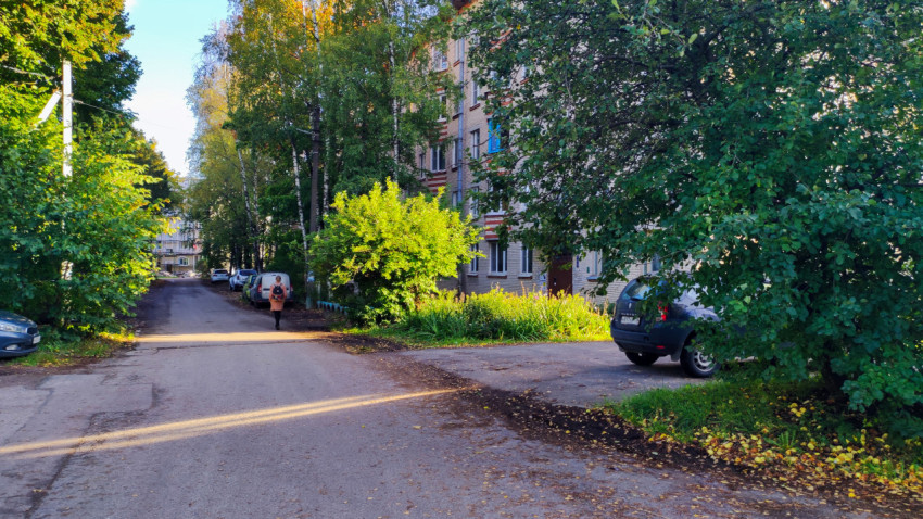 Асфальтированная улица с жилыми домами и деревьями