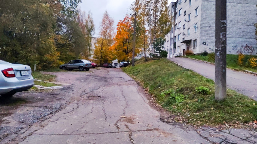 Двор с подъездом и парковкой у кирпичного дома