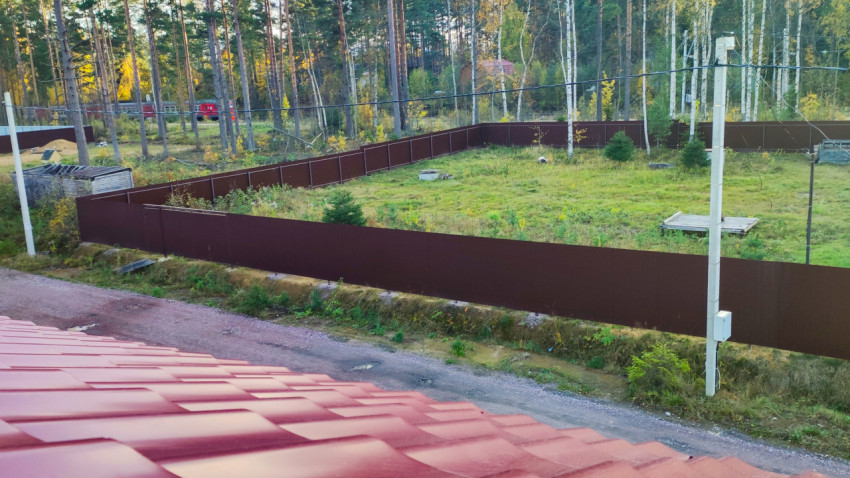 Участок с ограждением и коммуникациями в лесном массиве