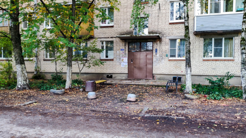 Подъезд многоквартирного дома с лавочками и деревьями