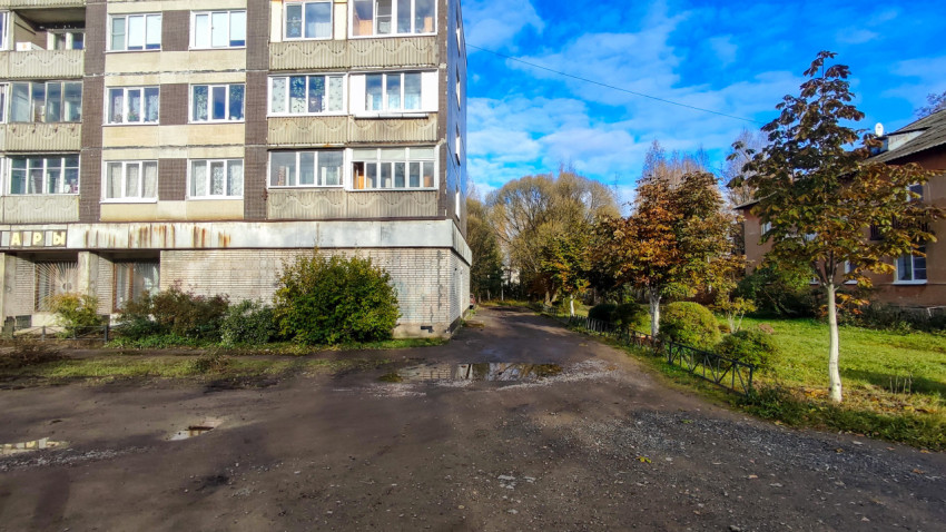 Панельный пятиэтажный жилой дом и двор с грунтовой дорогой