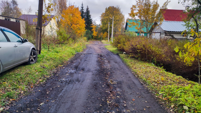 Грунтовая дорога в деревне с участками и линиями электропередачи