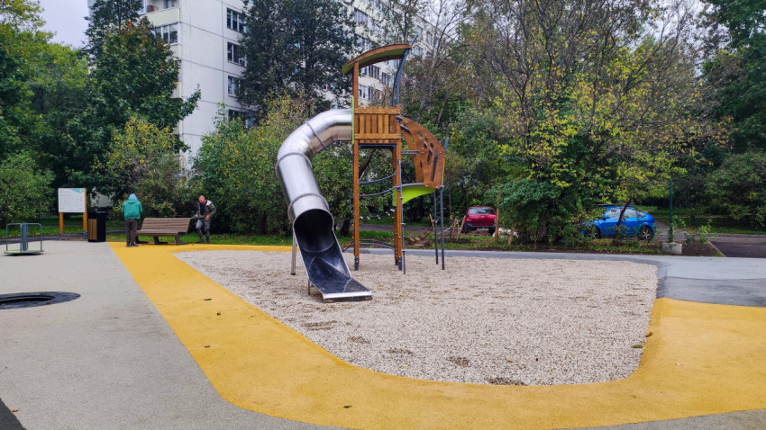 Детская площадка с металлической горкой и современным покрытием