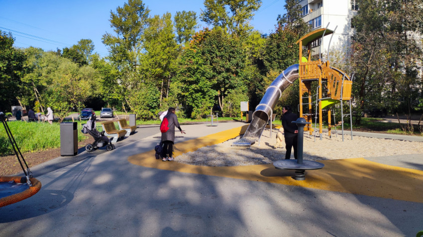 Современная детская площадка с металлической горкой во дворе