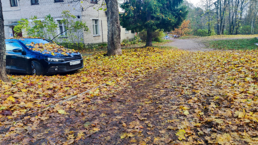 Автомобиль, припаркованный у жилого дома на грунтовом покрытии
