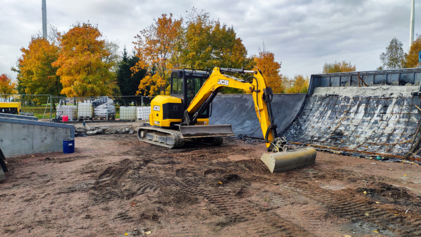 Мини-экскаватор JCB на площадке строительства бетонной рампы