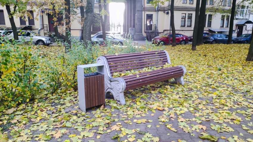 Лавочка и урна на придомовой территории в осенний период