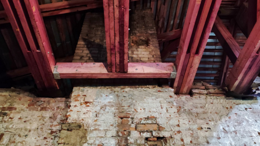 Участок кирпичной стены с новыми деревянными стропилами