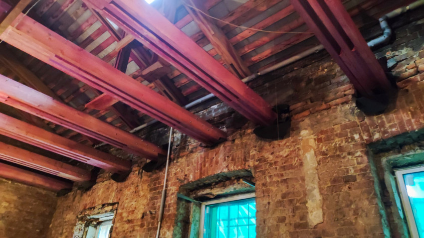 Потолочные балки и кирпичная кладка в процессе реставрации здания
