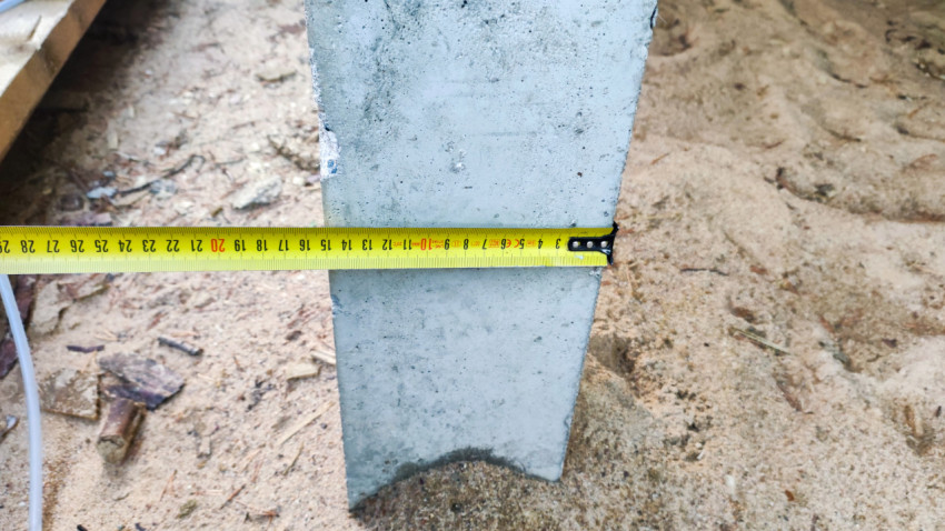 Измерение ширины бетонного фундамента рулеткой