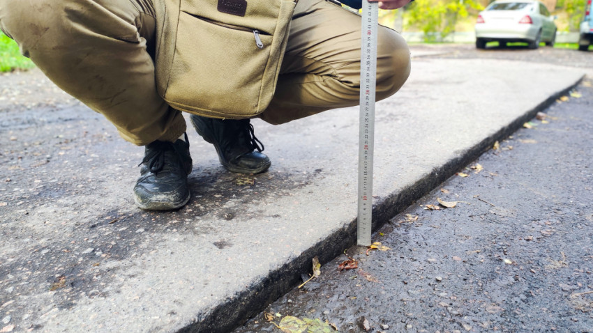 Проверка перепада высот между слоями асфальта на участке ремонта