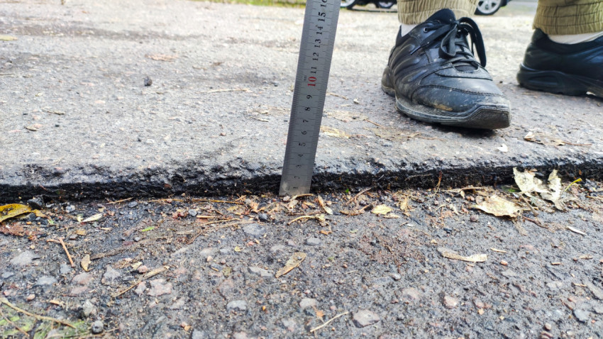 Замер толщины кромки асфальтового покрытия металлической линейкой