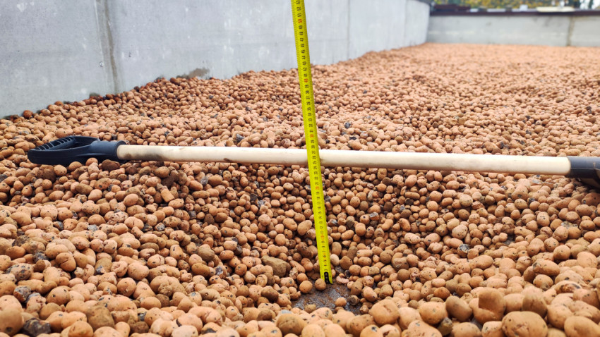 Замер толщины слоя керамзитового гравия на кровле рулеткой