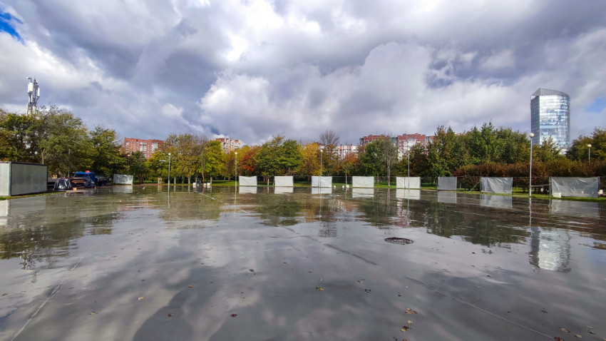 Городская бетонная площадка с отражением неба после дождя
