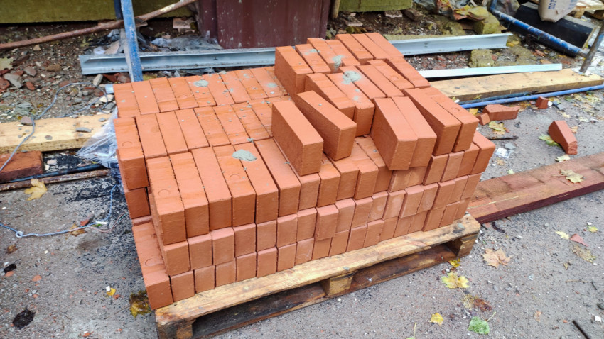 Палета с красным кирпичом на строительной площадке