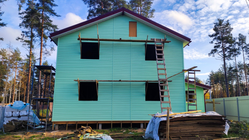 Строящийся двухэтажный дом с лестницей и временными подмостями