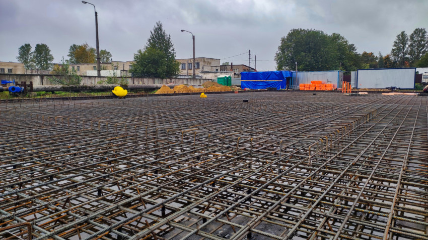 Строительная площадка с армированием плиты и строительными материалами