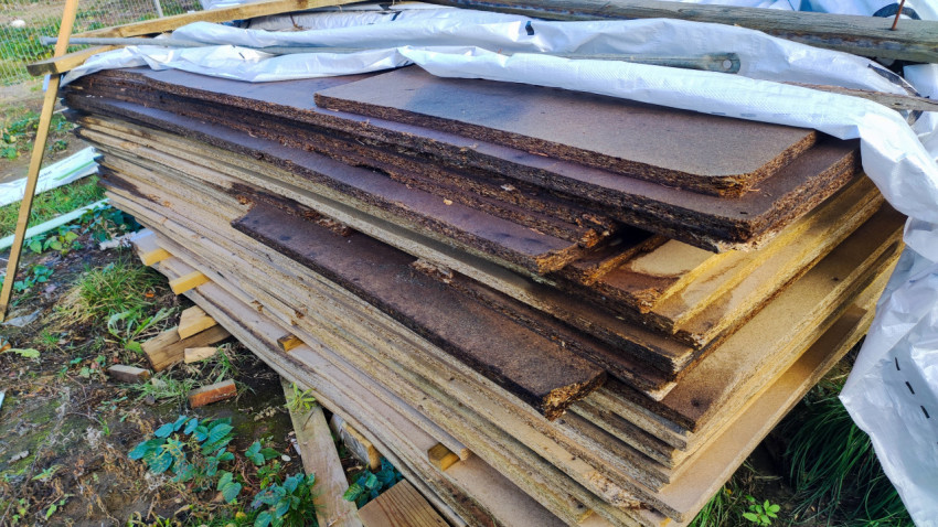 Плиты из древесных материалов, сложенные в штабель на участке