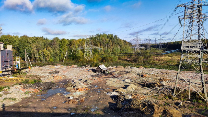 Опоры высоковольтных линий и строительный участок на фоне леса
