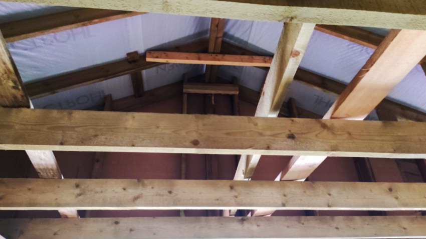 Внутренняя конструкция крыши с деревянными балками и стропилами