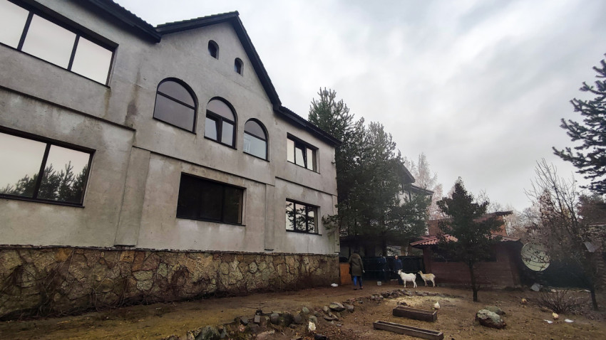 Осмотр фасада дома с арочными окнами и подсобными постройками